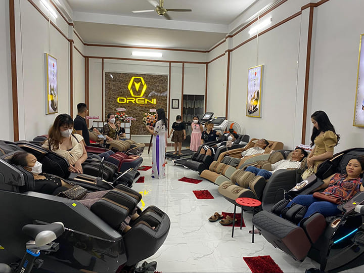 Khách hàng đang trải nghiệm ghế massage miễn phí tại cửa hàng